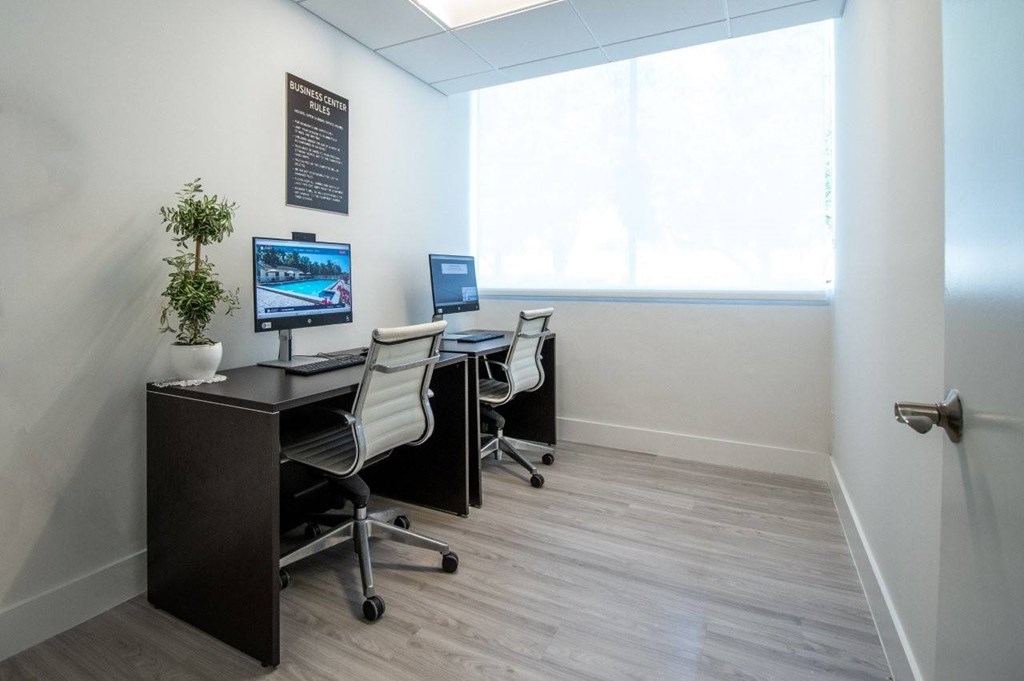 A room with a desk, chair, and computer monitor.