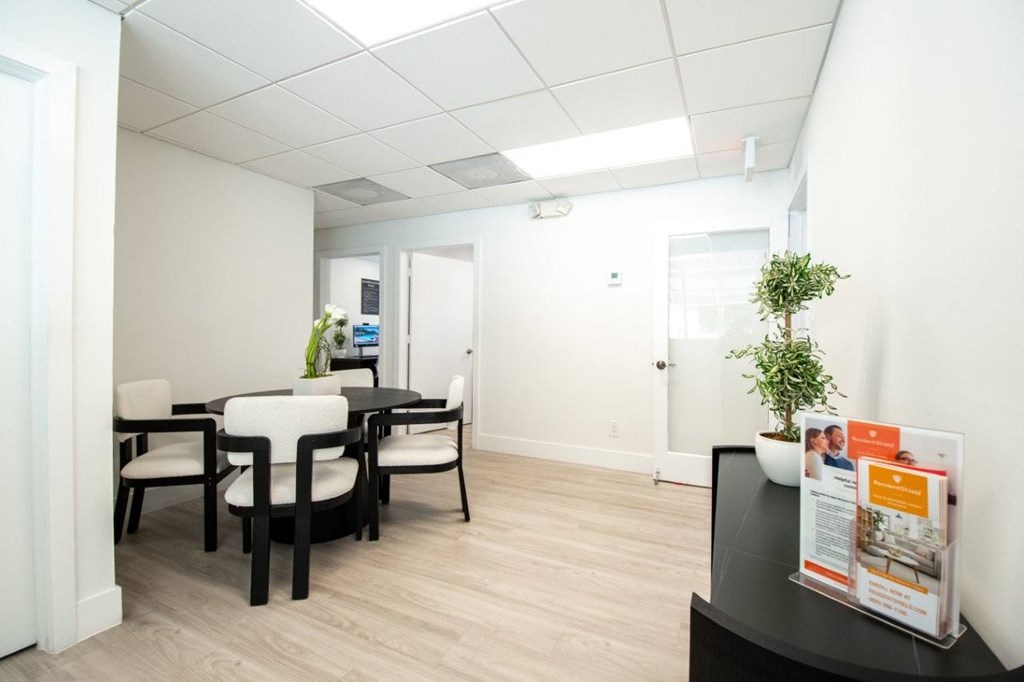 A conference room with a table and chairs and a poster on the table.