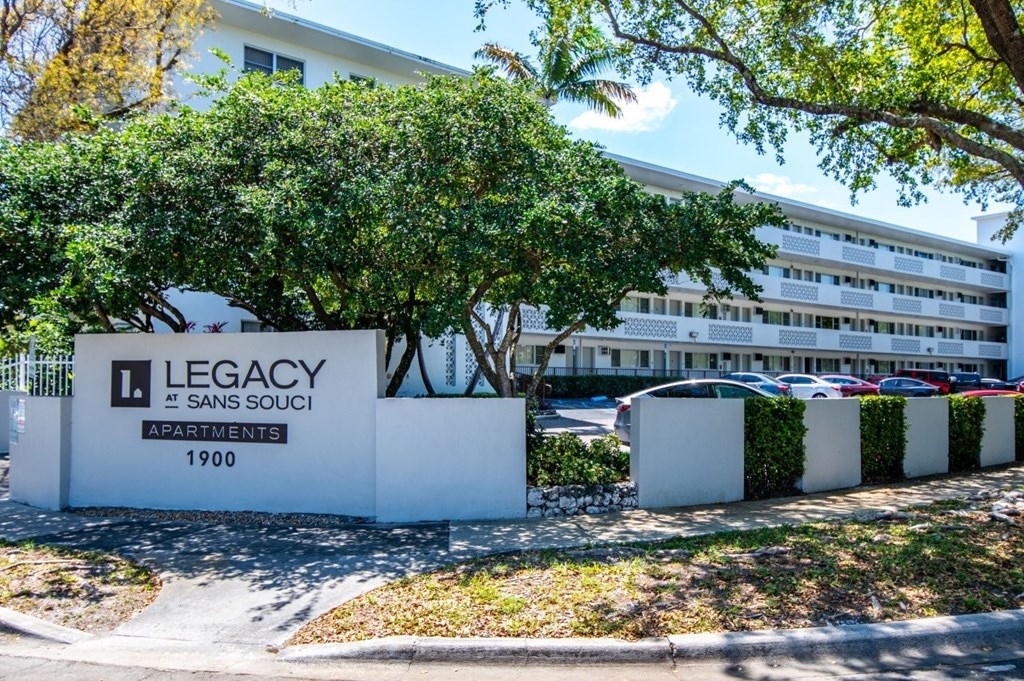 A white building with the words "Legacy" and "Sans Souci Apartments 1900" on it.