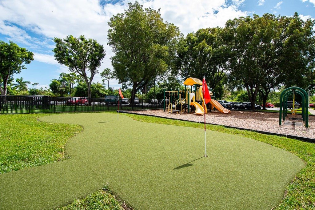 a park with a playground and a green golf course