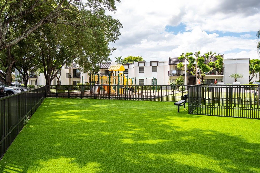 a yard with a playground and a bench