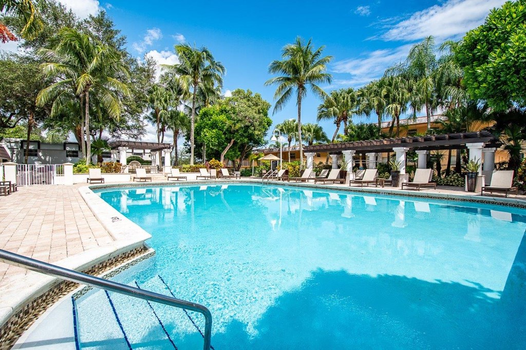 a large swimming pool with palm trees in the background