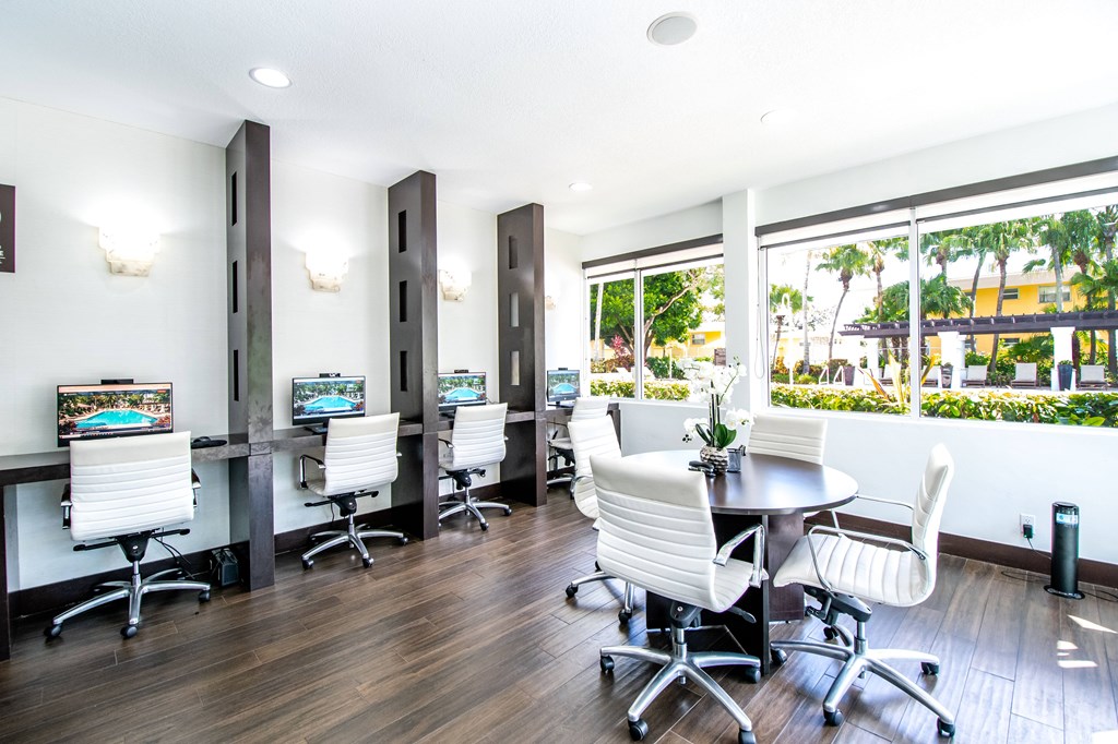 A room with a table and chairs and a computer on the table.