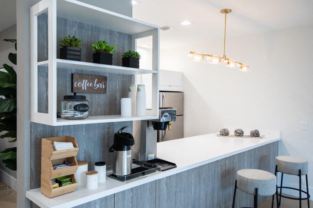 a white kitchen with a coffee machine and a counter