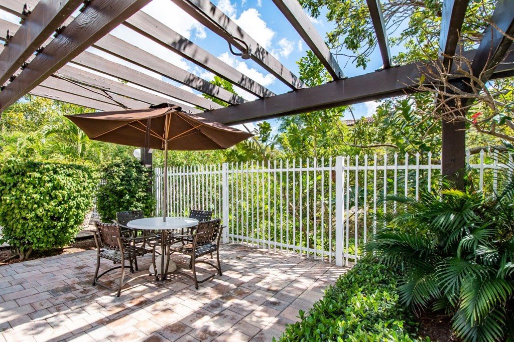 a patio with a table and chairs and umbrellas