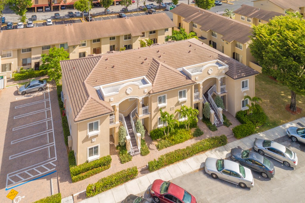 an aerial view of a house with cars parked in front of it