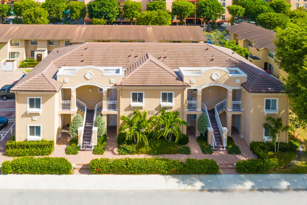 an aerial view of a large house with palm trees in front of it