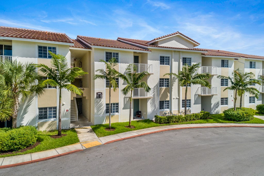 a large apartment building with palm trees in front of it