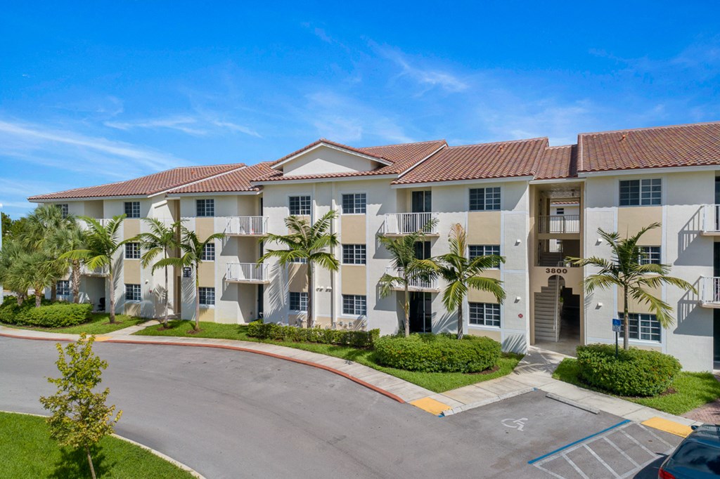 a large apartment building with palm trees in front of it