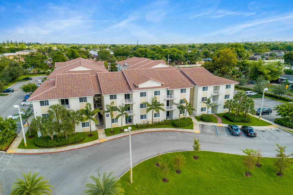 an aerial view of a large building with cars parked in front of it