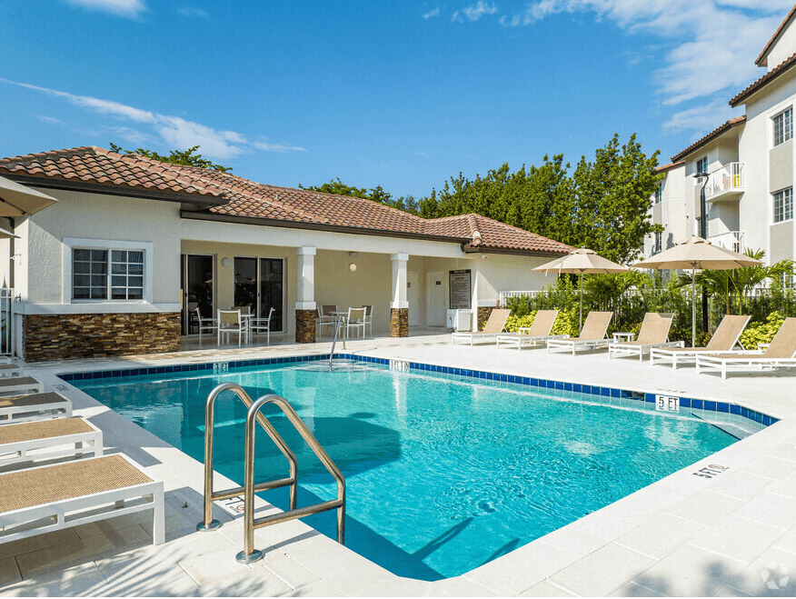 a swimming pool in front of a house with a resort style pool