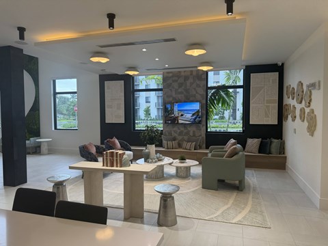 A modern living room with a large TV and a stone wall.