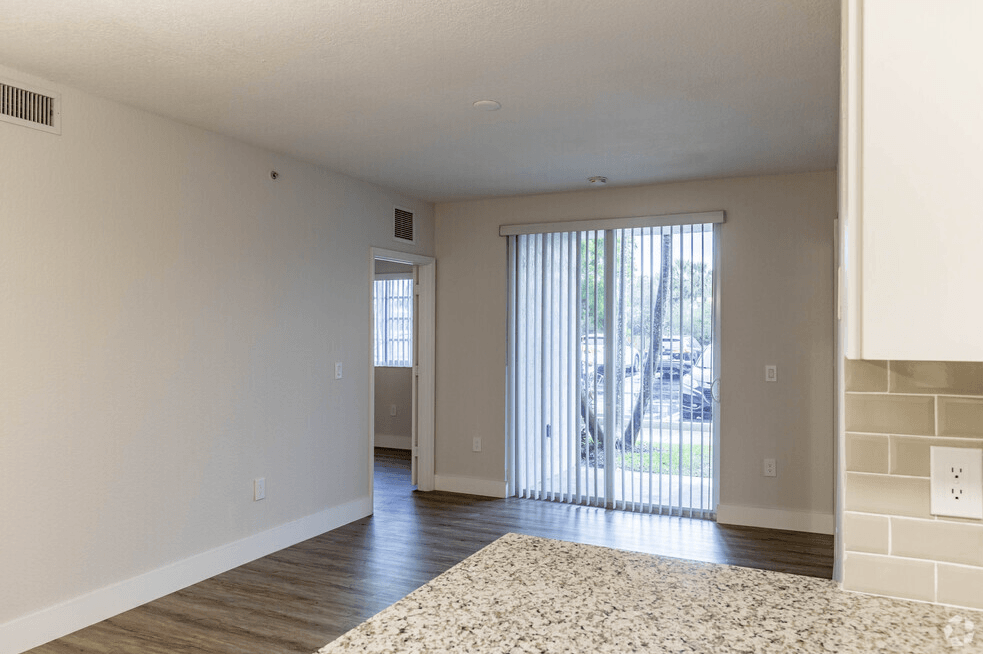 an empty living room with a sliding glass door to a patio