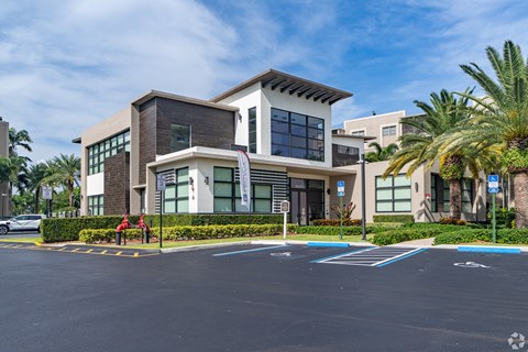 A modern building with a parking lot in front.
