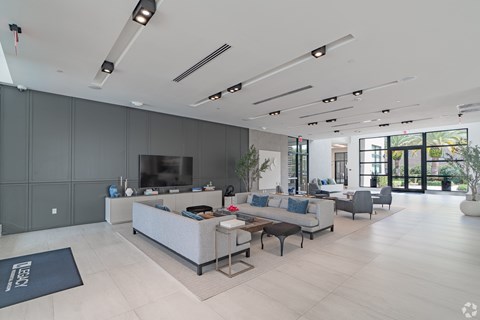 A modern living room with a grey sofa set and a television.
