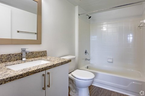 A bathroom with a sink, toilet, and bathtub.