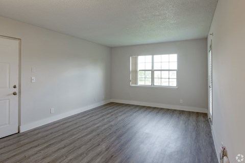 A room with a wooden floor and a window.
