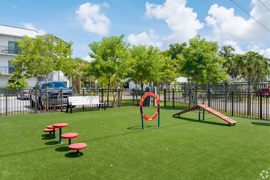 A playground with a red circular object and a bench.