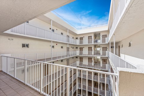 a balcony view of a building with white railing and a blue sky
