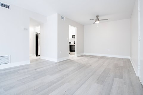 A room with a ceiling fan and a wooden floor.