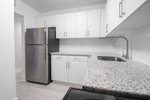 A kitchen with a granite countertop and stainless steel appliances.