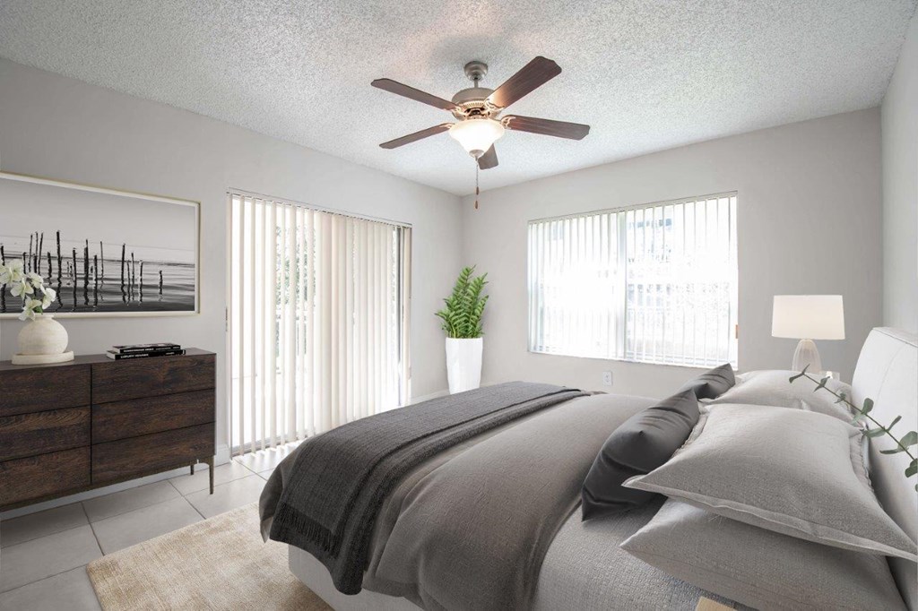 a bedroom with a ceiling fan and a bed