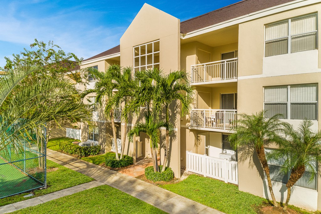 an apartment building with palm trees in front of it