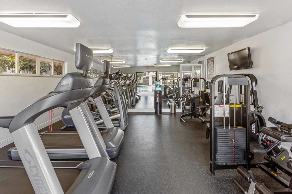 a gym filled with cardio equipment and weights