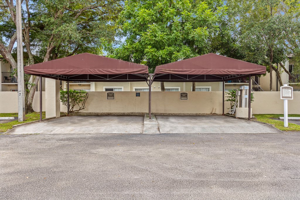 two umbrellas in a parking lot in front of a building
