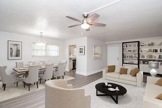 a living room and dining room with a table and a ceiling fan