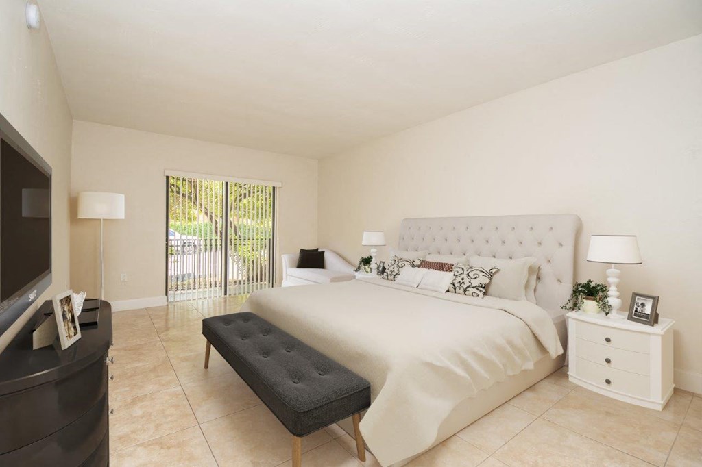 the master bedroom has a large bed and a tv