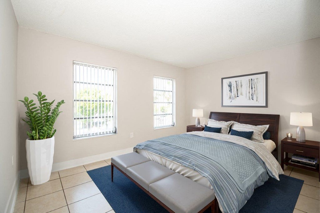 a bedroom with a bed and a potted plant