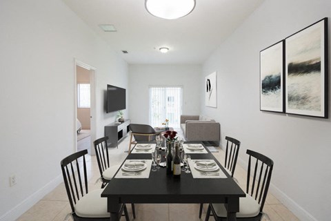 a dining room with a black table and chairs