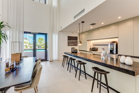 the kitchen and dining area of a modern house with a bar and stools
