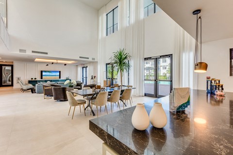 the living room and dining area of a house with high ceilings