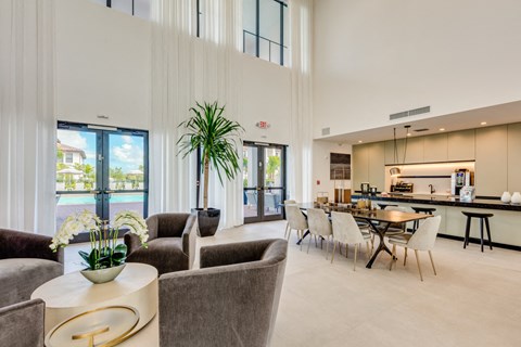 a living room with couches and chairs and a kitchen with a table and chairs