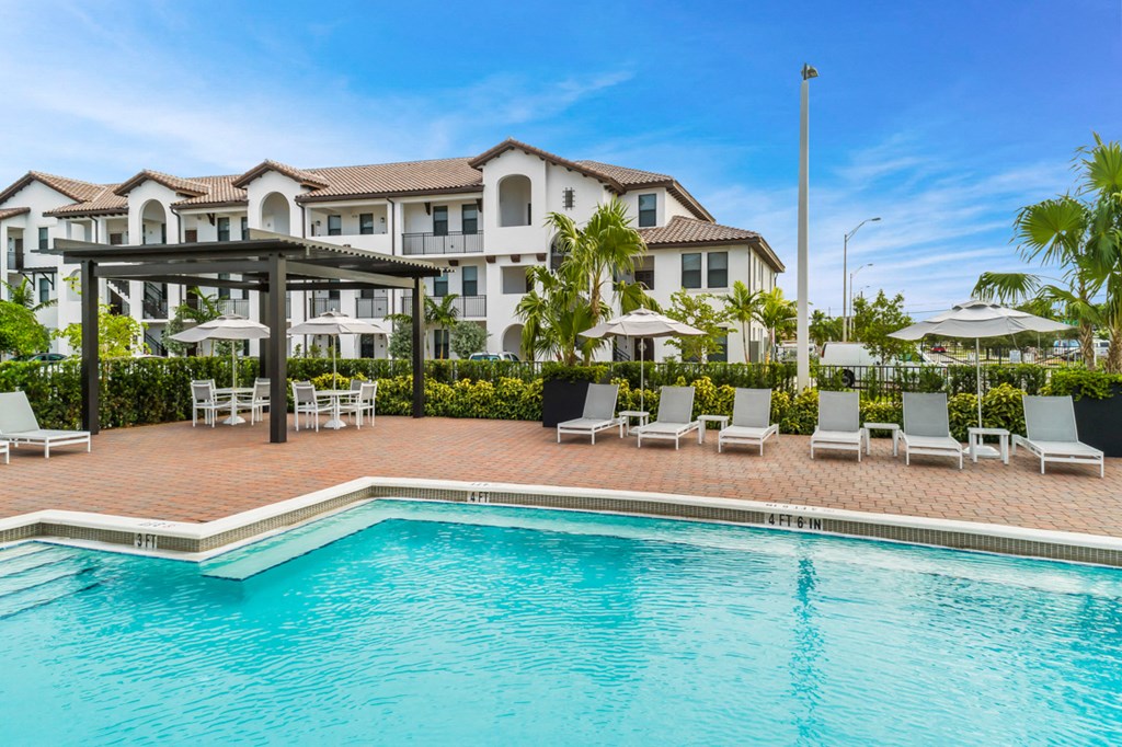 a swimming pool with chairs and umbrellas at a resort