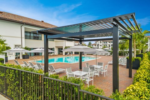 a swimming pool with chairs and umbrellas at a resort