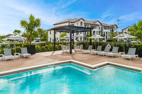 a swimming pool with chairs and umbrellas next to a resort pool