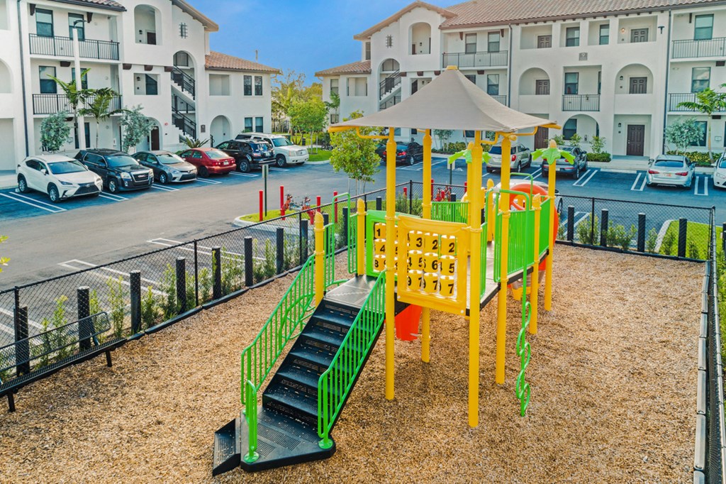 a playground with a slide and a umbrella