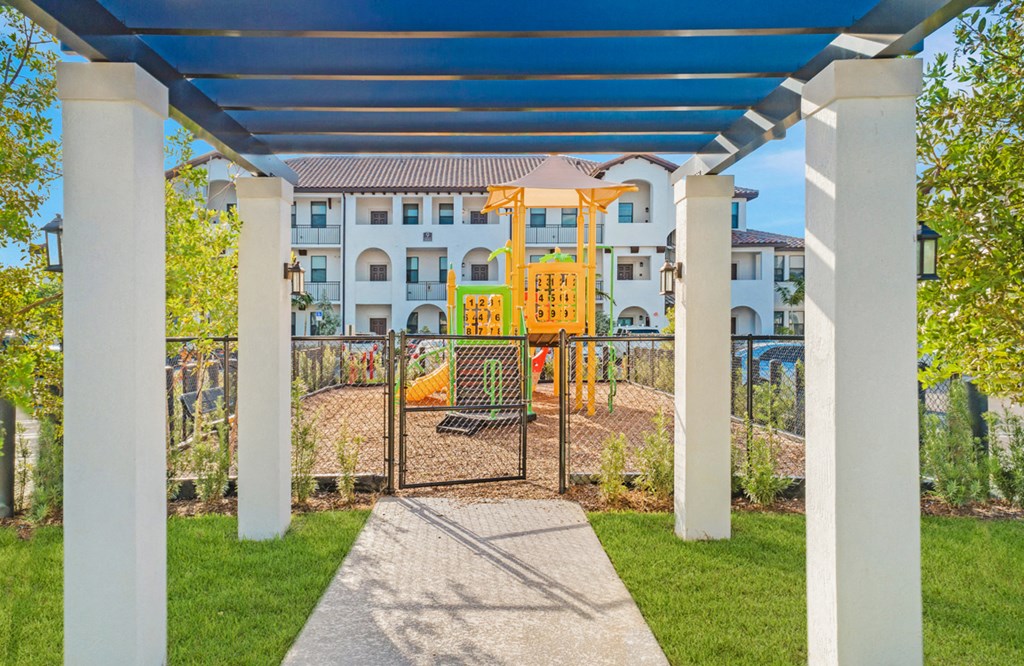 a playground area with a gate and a building in the background