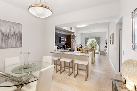 a dining room and kitchen area with a glass table and chairs