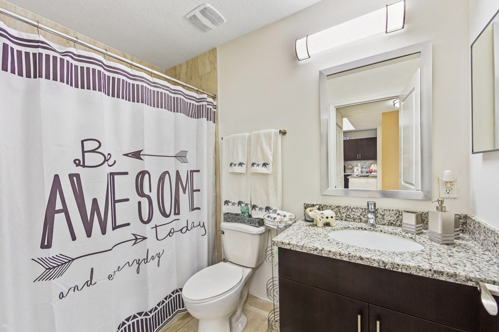 a bathroom with a shower curtain and a sink and a toilet