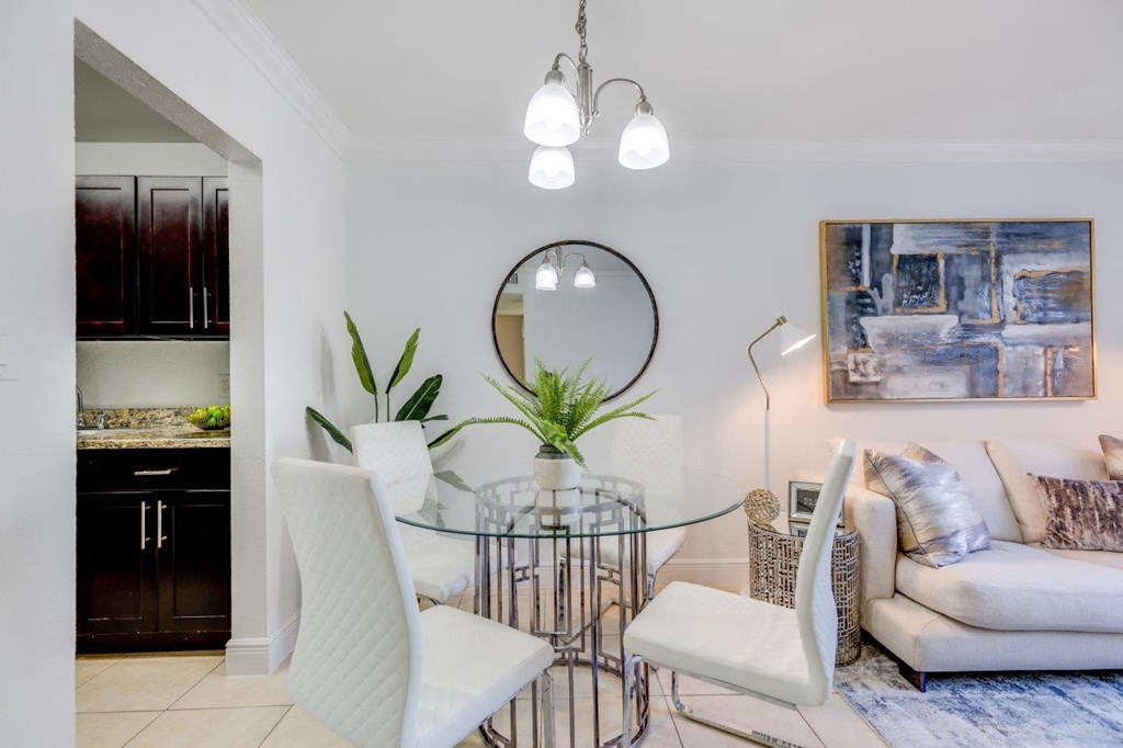 a dining room with a glass table and white chairs