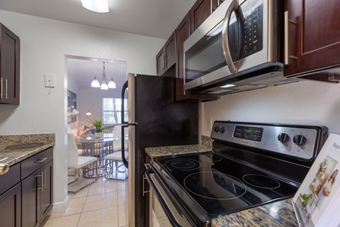 A kitchen with a black stove top oven and a black microwave above it.