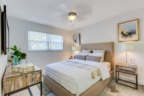 A bedroom with a large bed and a painting on the wall.