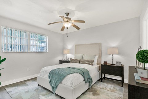 a bedroom with a bed and a ceiling fan