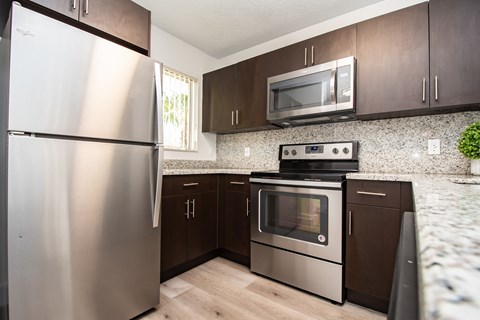 A kitchen with a stainless steel refrigerator and a stainless steel oven.