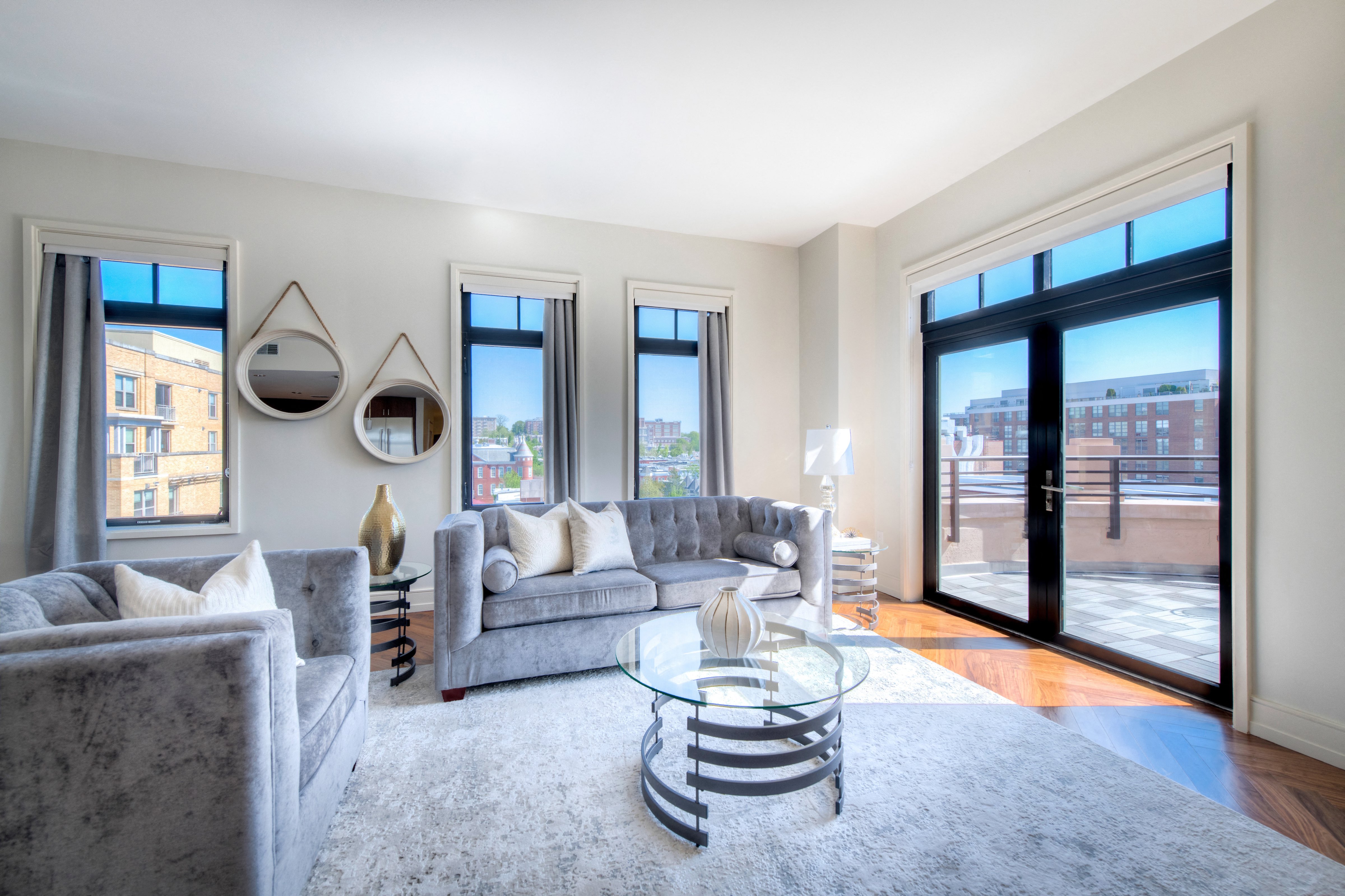 a living room with couches and a glass coffee table