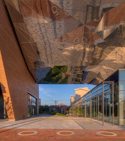 a view of the outside of a building with glass windows and a walkway